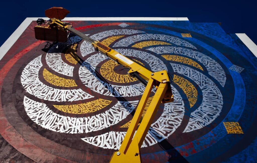 Artista urbano mexicano Said Dokins realizando un mural de caligrafía en Ibiza, España para el Bloop Festival