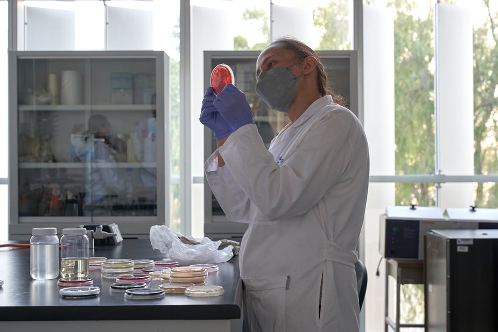In a laboratory at Tec de Monterrey, the contemporary artist Said Dokins is shown in the midst of a work-in-progress experimentation for the Bio Recrituras project. Dra Carmen González, Aurea Ramírez and Paola Angulo working with the artist